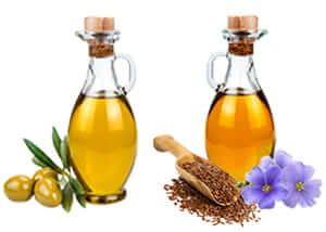dos frascos de cristal uno de aceite de oliva con aceitunas y otro de lino con semillas y la flor de linaza